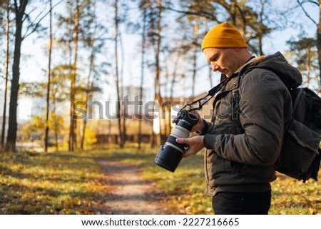 Young photographer taking photo in the forest.