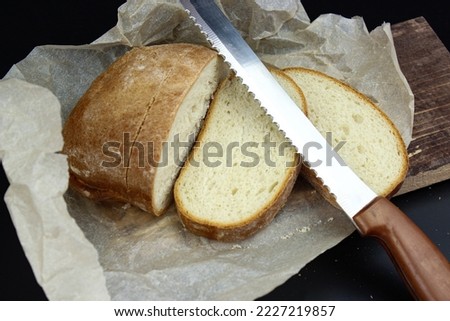 Bread Knife Slice. Sliced bread on a wooden cutting board and knife.
