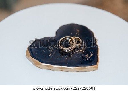 wedding rings lie on a background in the shape of a heart in blue