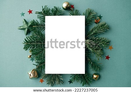 Christmas card flat lay. Modern greeting card mock up with stylish christmas decorations, fir branches, ornaments on green background. Empty postcard template with space for text. Merry Christmas!