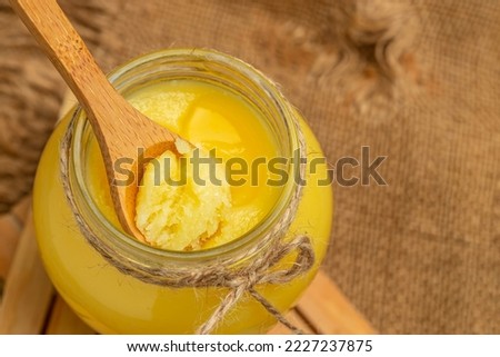 ghee oil. Ghee or clarified butter in jar on a wooden background. banner, menu, recipe place for text. Royalty-Free Stock Photo #2227237875
