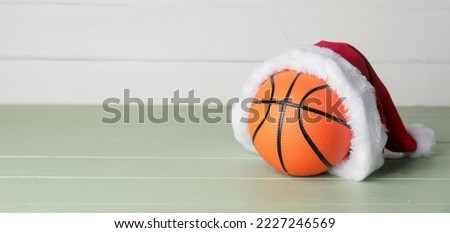 Santa hat and ball for playing basketball on table