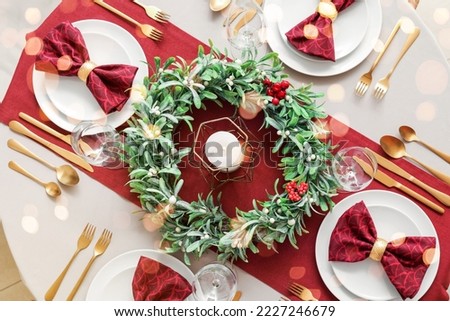 Christmas table setting with mistletoe wreath in dining room, top view Royalty-Free Stock Photo #2227246679