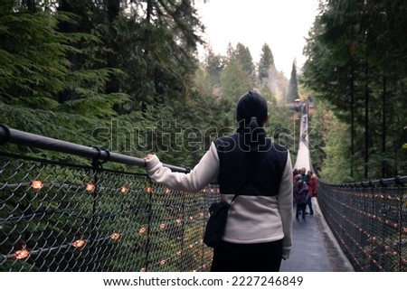 Canada Autumn travel destination in British Columbia. Tourists walking in famous attraction Capilano Suspension Bridge Park in North Vancouver, Canadian vacation for tourism. Royalty-Free Stock Photo #2227246849