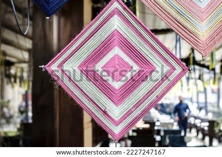 Decorative rhombuses from colored threads on the background of the old city. Festive element decor photo.