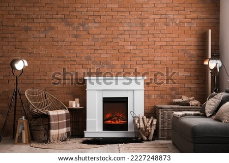 Interior of living room with fireplace, armchair and glowing lamps