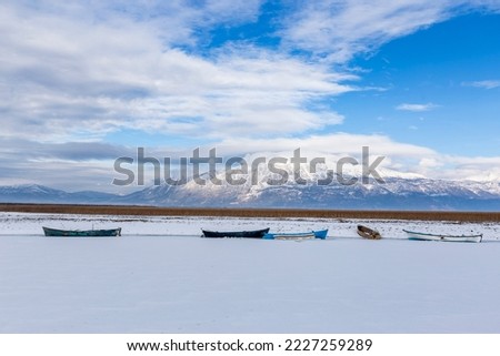 Boat, lake and mountain scenery in snowy weather