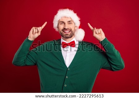 Photo of cheerful funky guy toothy smile indicate fingers newyear headwear isolated on red color background