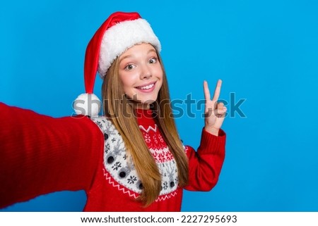 Portrait of funny positive cheerful girl with blond hair wear red sweater showing v-sign make selfie isolated on blue color background