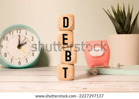 Wooden blocks with the word Debt. Reduction or restructuring of debt. Refusal to pay debts or loans and invalidate them Royalty-Free Stock Photo #2227297137