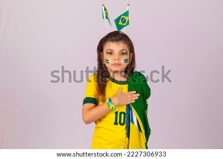adorable little fan girl from Brazil with her hand on her chest in reverence to the national anthem