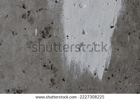 Texture of old concrete wall. Rough grey surface of concrete with a white smear of paint. Perfect for background and design. Close-up. High resolution.