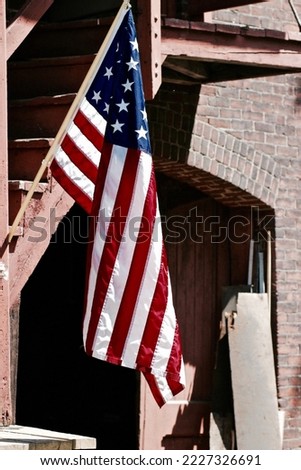 An American Flag hanging in front of an old train station