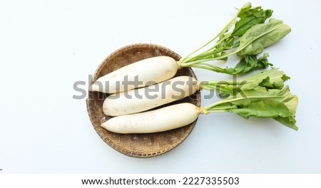 resh white daikon, daikon radish, radish, white radish,(raphanus sativus var. longipinnatus) 
in a wooden basket isolated on white background.flat lay Royalty-Free Stock Photo #2227335503