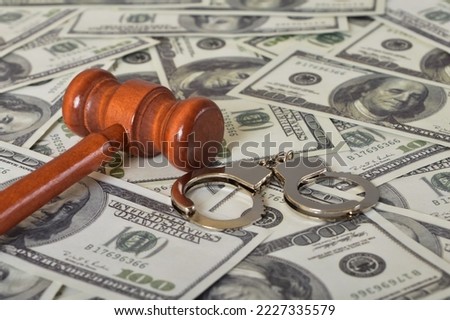 Judge gavel, handcuffs and money banknotes. Economic crime, scam, bail and corruption concept. Royalty-Free Stock Photo #2227335579