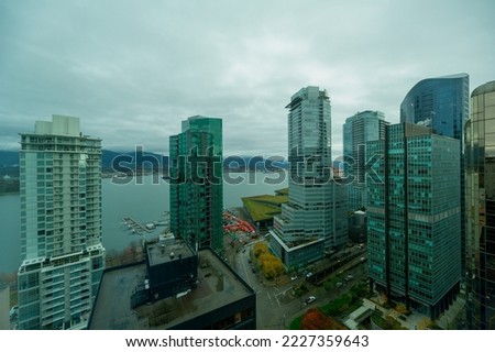 An aerial view of downtown Vancouver, looking towards Coal Harbour. Docked seaplanes are visible on the pier.