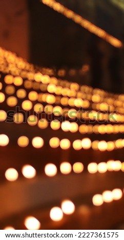 Close up shot of Dev Deepawali 2022 festival, Earthen lamps lit on the stairs leading to the Ganges with selective focus. Thousands of diyas (oil lamps) are lined up on the stairs near Ganges.