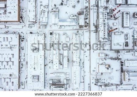 urban industrial area with manufacturing buildings, warehouses and thermal power plant at winter time. aerial top view.