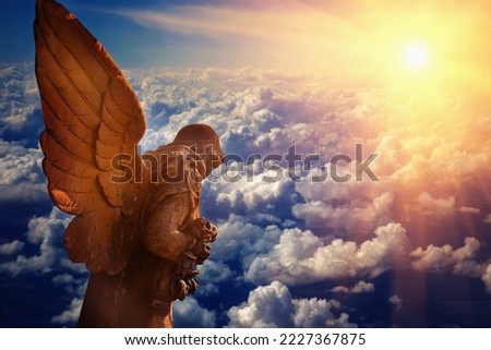 Antique statue of wonderful angel in the rays of the sun. Architecture, archetype, religion, faith concept. Horizontal image.