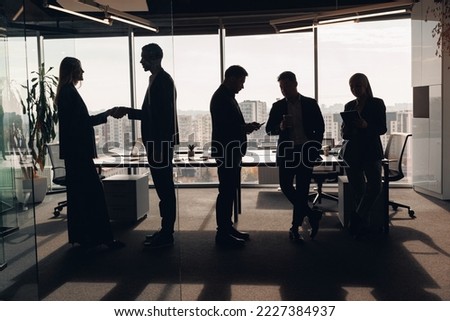 Silhouette photo of coworkers cooperating and working together at office meeting, teamwork concept