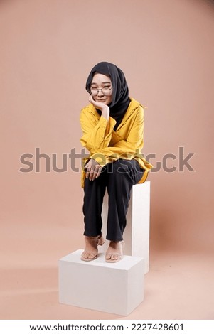 Cute young Asian hijab corporate girl with smooth glowing skin smiling and relaxing over an isolated background studio. Beauty skin care, office concept.
