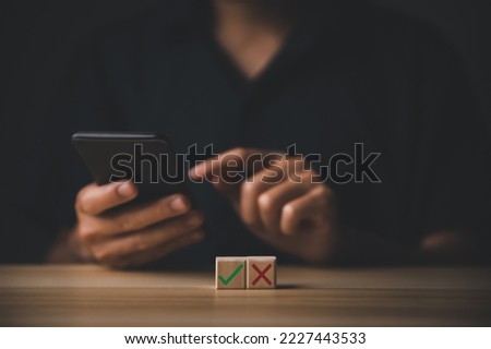 businessman and wooden block showing checks marks and wrong. The idea is to decide to vote. think yes or no Business options for difficult situations true and false symbols. with clipping path.