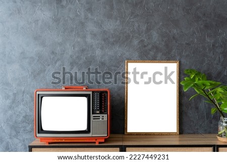 tv room, living room. Mock up gold picture frames on a dark loft wall and a vase of plants on the TV cabinet.
