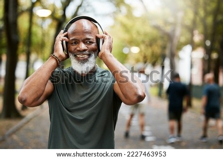 Fitness, headphone and senior black man, music and exercise in nature park, portrait and running for health and wellness. Elderly runner, streaming and podcast while training, workout and run outdoor