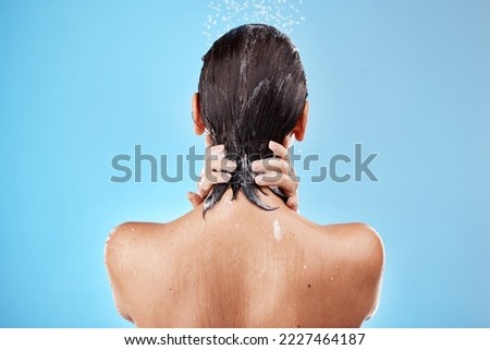 Back, woman and shower for hygiene, bathroom and freshness on blue studio background. Mockup, female and healthy girl with water, clean and wet for wellness, skincare and health with drops and splash Royalty-Free Stock Photo #2227464187