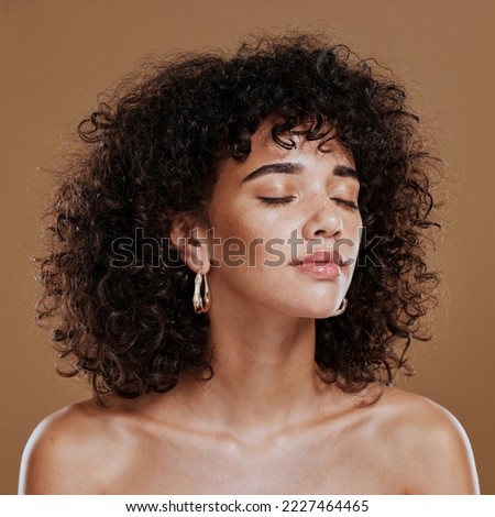 Woman, beauty and freckles, curly hair and facial treatment, makeup and body care aesthetics, shine or glow on studio background. Young model, melasma face and natural cosmetics, skincare or wellness Royalty-Free Stock Photo #2227464465