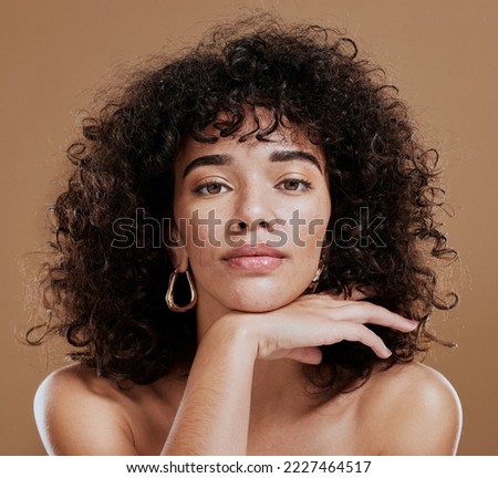 Makeup, confident and portrait of a woman with hair care, skincare and beauty against a brown studio background. Face, cosmetic and young girl model with a curly afro, cosmetics and empowerment