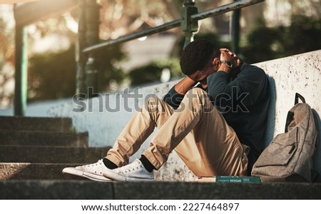Student, mental health and depression with anxiety, burnout and sad for exam results, fail or mistake while sitting outdoor. Young man, stress and tired and depressed on university or college campus Royalty-Free Stock Photo #2227464897
