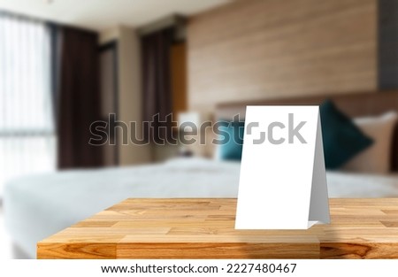 White sign cardboard with copy space on a white round table. Hotel interior