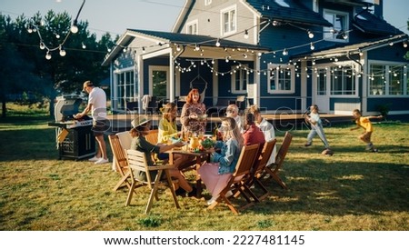 Parents, Children and Friends Gathered at a Barbecue Dinner Table Outside a Beautiful Home. Old and Young People Have Fun, Eat and Drink. Garden Party Celebration in a Backyard. Royalty-Free Stock Photo #2227481145
