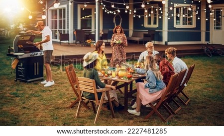 Family and Multiethnic Diverse Friends Gathering Together at a Garden Table. People Cooking Meat on a Fire Grill, Preparing Tasty Salads for a Big Family Celebration with Relatives. Royalty-Free Stock Photo #2227481285