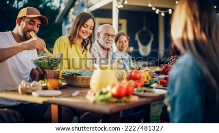 Big Family and Friends Celebrating Outside in a Backyard at Home. Diverse Group of Children, Adults and Old People Gathered at a Table, Kids Running and Having Fun. Royalty-Free Stock Photo #2227481327