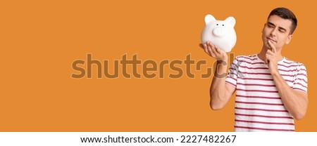 Thoughtful man with big piggy bank on orange background with space for text