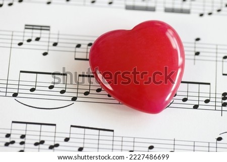 Red heart with musical notes closeup. Music note book with heart, love songs concept.