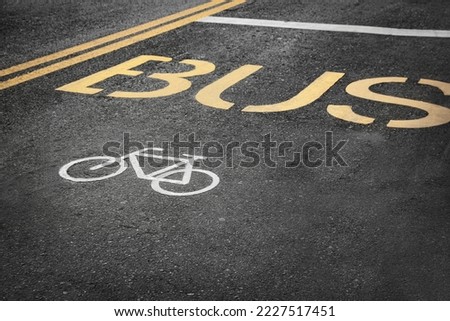 Bicycle and bus lane signs painted on asphalt