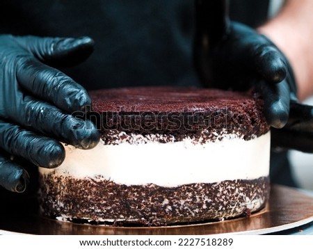 Chef cake designer preparing layered creamy cake base for frosted decoration and topping