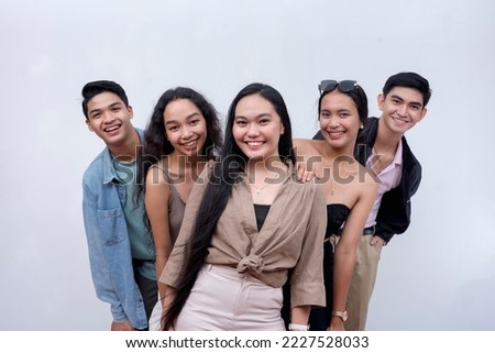 5 happy and young friends in their late teens to early 20s looking at the camera. Modern Gen Z team. Isolated on a white backdrop. Royalty-Free Stock Photo #2227528033