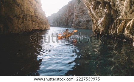 Cave kayaking, man kayaking in narrow terrain