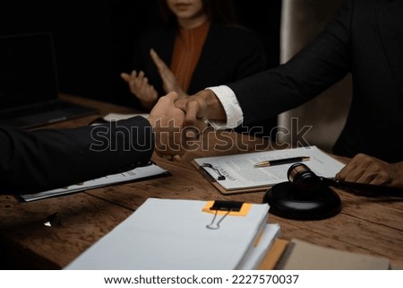 Close up lawyer businessman working or reading lawbook in office workplace for consultant lawyer concept.Lawyer working at table in office, focus on scales of justice