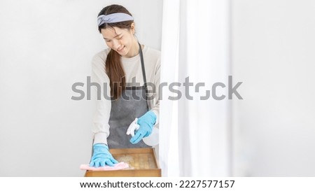 Housewife is cleaning things and Storage cabinet or showcase in the living room, Big cleaning, Housework, Daily routine ,Removes germs and dirt and deep stains, Spray alcohol, Clean up on weekends. Royalty-Free Stock Photo #2227577157