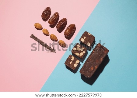 Protein date fruit candy bars fitness with nuts and fruit almond and chia poppy seeds top view on blue pink background with copy space and place for text