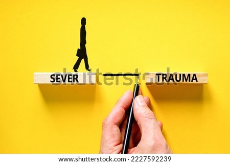 Sever trauma symbol. Concept words Sever trauma on wooden blocks. Beautiful yellow table yellow background. Psychologist hand. Psychologist icon. Psychological and sever trauma concept. Copy space.