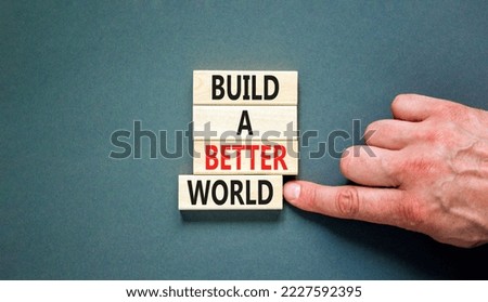 Build a better world symbol. Concept words Build a better world on wooden cubes. Beautiful grey table grey background. Businessman hand. Business build a better world concept. Copy space.