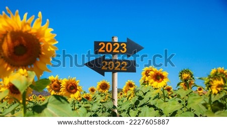 Road sign for year 2023 in sunflower garden