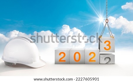 construction start working in the new year 2023. Success real estate, teamwork, and a healthy environment.Construction-crane lifting the cube and number 3 replace the year 2022 Royalty-Free Stock Photo #2227605901