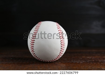 Baseball ball on wooden table, closeup. Sportive equipment